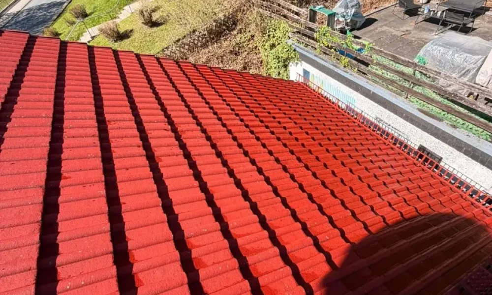 Professionell gereinigtes rotes Ziegeldach nach der Dachpflege